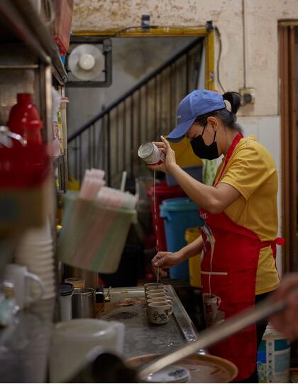 A member of kitchen staff makes coffee