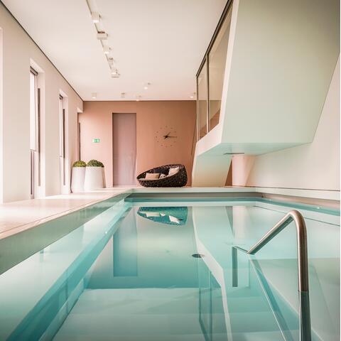 The architectural, pink-hued pool room at the Susanne Kaufmann Spa at SO/ Berlin Das Stue